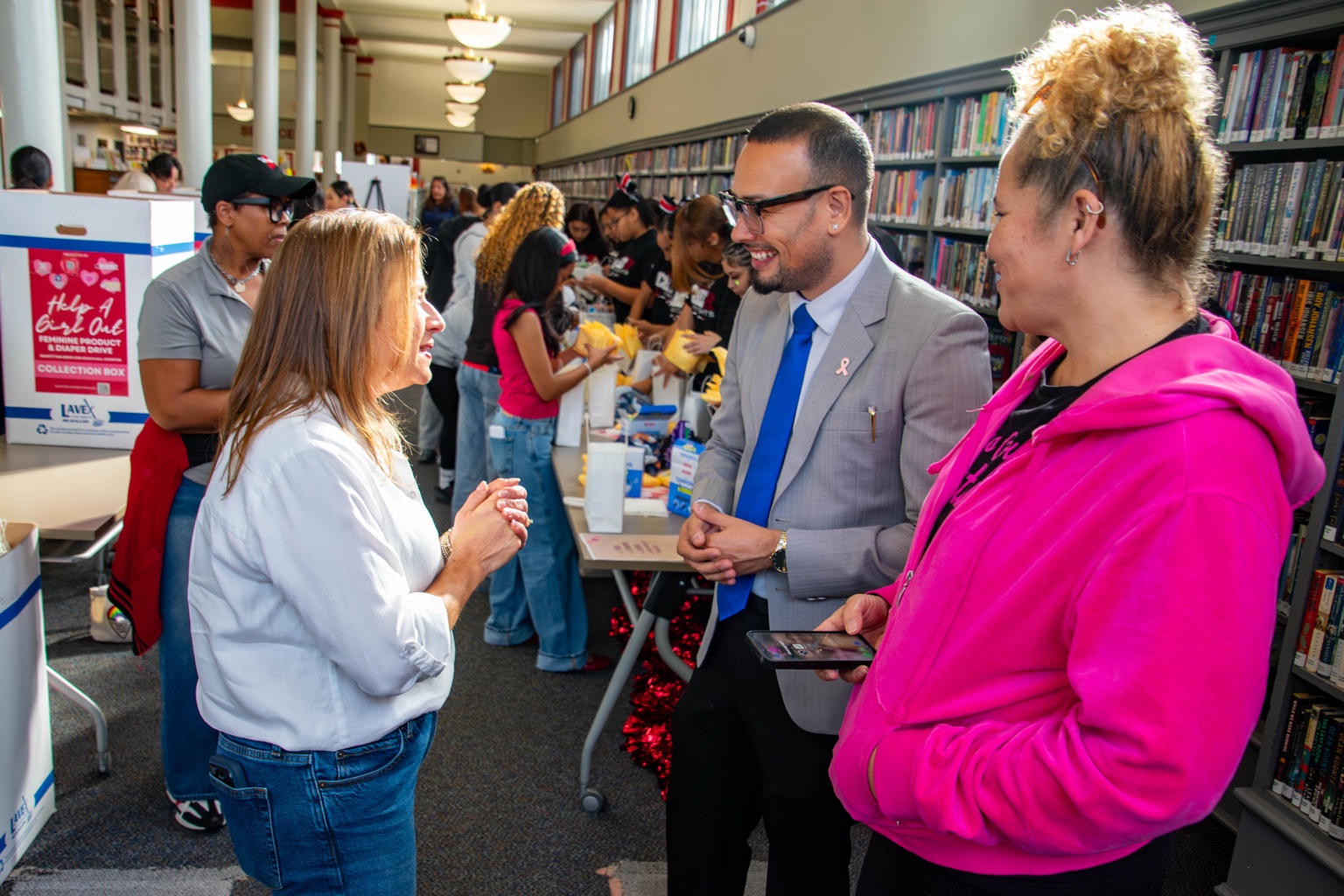 Jaime Báez Jr. in conversation at a community gathering in a library