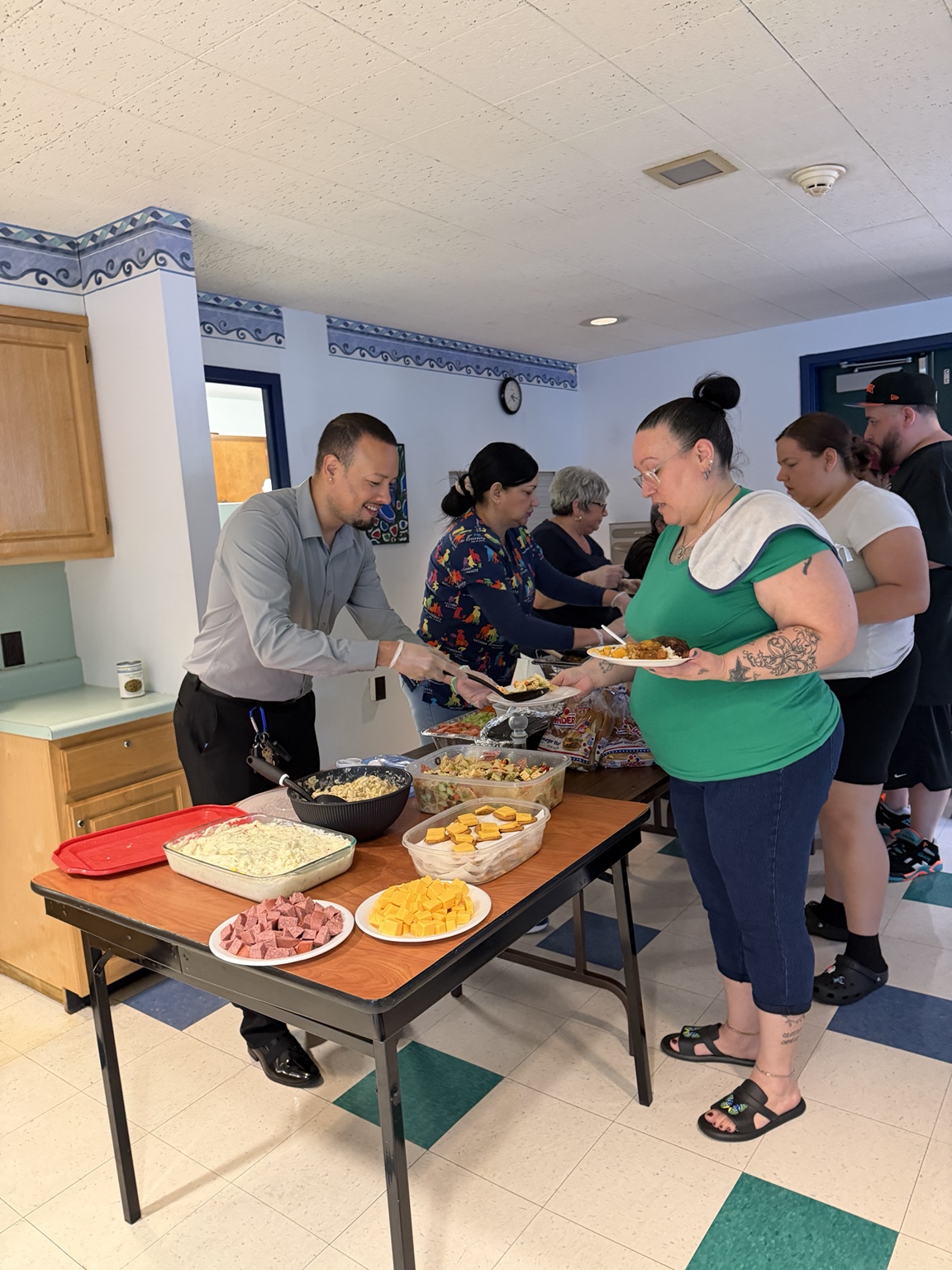 Jaime serving food alongside volunteers at a community gathering