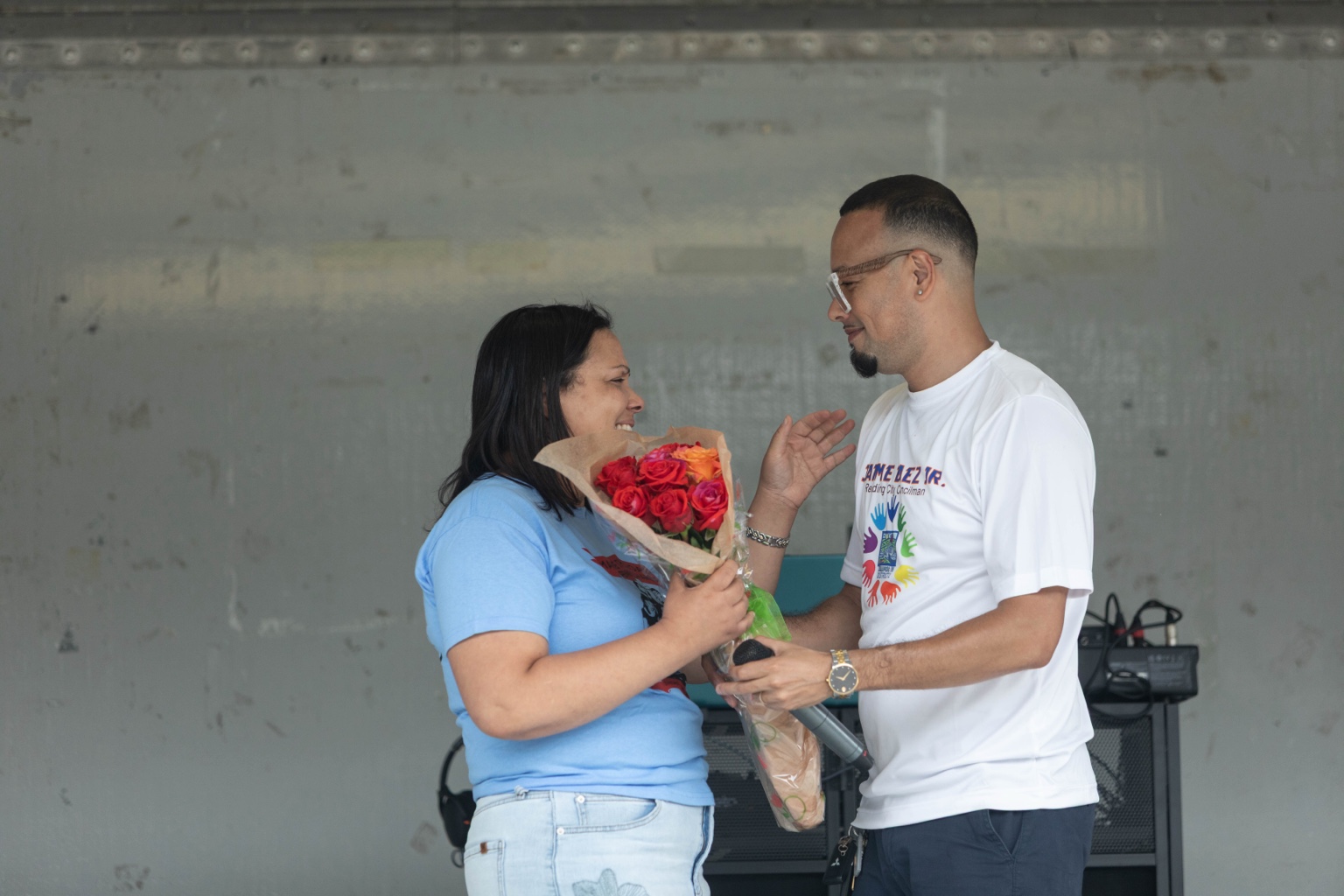 Jaime and a community member holding flowers during the event